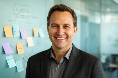 Nhlanhla Erpen smiling in a modern office beside a data planning wall